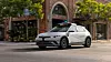 Motional Hyundai Ioniq 5 robotaxi with roof sensors driving past brick shops
