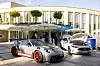 Porsche and Mercedes-Benz cars on display outside a conference building