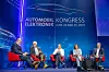 Panel discussion on stage at Automobil Elektronik Kongress 2025 with five seated speakers.