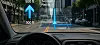 View from driver seat showing augmented reality navigation on car windscreen in city street