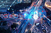 Night-time aerial view of a busy road junction with bright vehicle light trails.