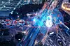 Night-time aerial view of a busy road junction with bright vehicle light trails.