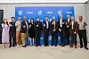 Group of people standing in front of an Uber-branded backdrop at a technology event.