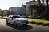 Mercedes-Benz CLA 250+ with EQ Technology driving past houses on a sunny suburban street.