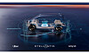 Futuristic transparent concept car displayed on a dark stage with Uber, Stellantis and Wayve logos.