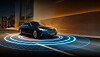 Black Mercedes-Benz sedan driving through a tunnel with blue illuminated rings on the road.