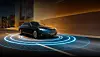 Black Mercedes-Benz sedan driving through a tunnel with blue illuminated rings on the road.