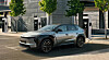 Silver SUV parked outside a modern building on a sunny city street.