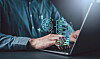 Hands typing on a laptop with glowing digital security and server icons on screen.