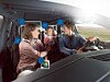 People inside a car with facial recognition icons overlaid on the image.