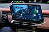 Car dashboard touchscreen displaying a navigation map and lane guidance.