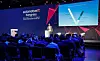 Speaker on stage presenting at the automotive IT Kongress to an audience in a conference hall.