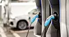 Charging plugs connected to electric vehicles at a station.