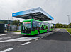 Green Mercedes-Benz eCitaro bus parked under a charging canopy in Ljubljana.