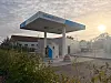 A H2MOBILITY hydrogen refuelling station on a misty morning with the sun low in the sky.